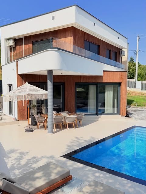 Oborri i Villa Aroo në mëngjes, me tavolinën jashtë dhe pishinën në plan të parë