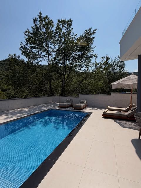 Pishina verore e Villa Aroo me shezlonë prej druri dhe çadër makrame